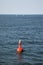 Red buoy floating atÂ open sea